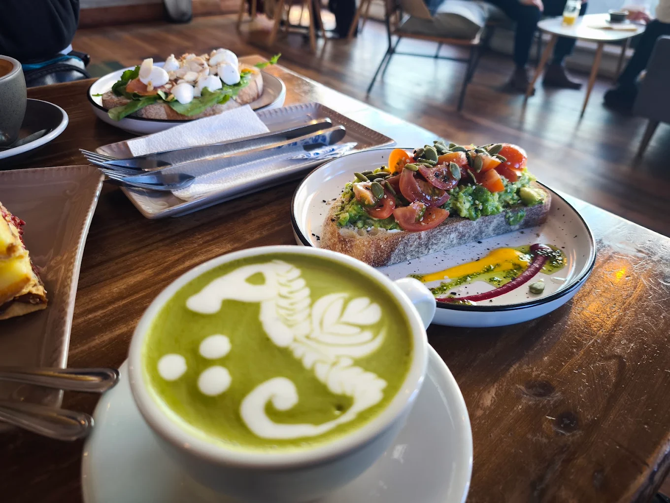 Tostada de masa madre con palta y tomates acompañada de matcha latte con arte de caballito de mar en Terra